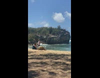 Man white sleeveless top jump shot beach