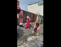 Man in white jumpsuit dances street snow