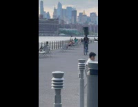 Biker balances trash can on head with backpack 