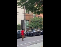 Collab WINY - Man walking red shirt balancing refrigerator on head 