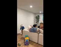 Men pretends to be startled with kid wearing Halloween mask