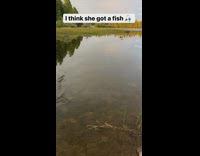 Little girl catches a fish from the lake