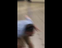 Two guys fighting with wet floor cones subway train station