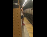Man red shoes lifts kettlebell weight in subway station 