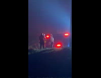 Man shirtless films with wildfire behind him
