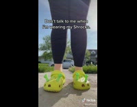 Girl shows off yellow green shrek crocs