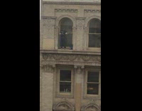Man cleaning windows black shirt no harness or security