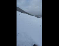guy in green jacket falls in deep snow