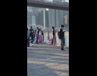 Woman in black bikini poses by the river park fence