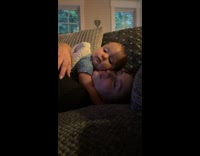 Baby on top of mom cuddling and hugging couch