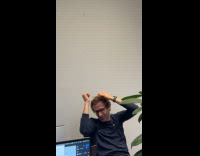 Man spinning sign on wall falls on his head 