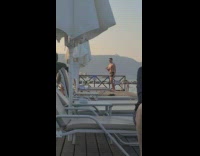 Shirtless man drink from glass beach platform