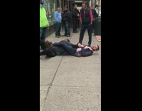Guy has another guy in armbar on floor of sidewalk in altercation