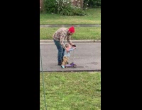 Dad red beanie films baby on scooter