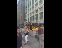 Shirtless man stand on barricade play flute