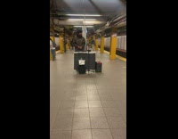 Guy djing live music in middle of subway station platform