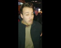 Guy drinks alcohol out of a Heinz ketchup bottle at a concert