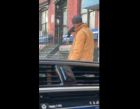 Man stands on street talks with pigeon