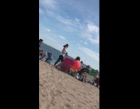 Lady whips leather mask guys face beach 