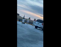 Two girls hold hands skate circles rooftop