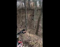 Guy drives dirtbike up steep leaf hill and falls down then gets hit by bike