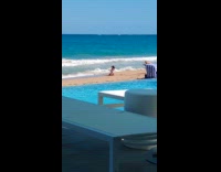 Girl white swimsuit kneel hold hair beach