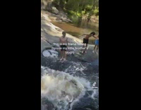 Guy falls backwards in small waterfall