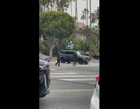 Woman in a black dress crosses the pedestrian lane
