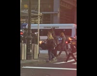 Person crosses street with black item on head 