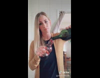 Woman pours wine into Pom juice bottle