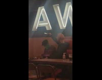 Guy films DJ phone restaurant white hat 