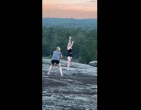 Black shirt girl grey rock sunset trees