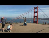 Guy does head stand by bridge 