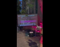 A girl coding on big screen on street