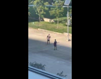 2 men doing whipping practice on parking lot 