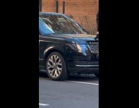 Man stands on car hood at street