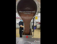 Machine pouring out out brown batter into machine