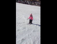 Little girl turned and skis backwards downhill