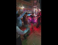 Guy dances to club music on sidewalk 