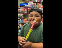 Kid at convenience store putting giant slim jim in mouth
