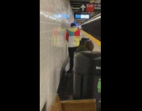 Guy pees by subway station white wall 