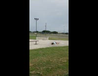 Skater jumps onto rail with skateboard, slips and falls flat on the floor at skate park