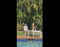 Woman black hat swimsuit side pose pool