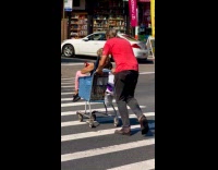 Elderly man pushing shopping cart with wife on it 