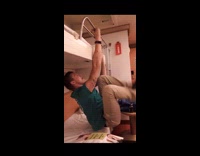Guy blue shirt hands upside down legs up on bunk bed rail, breaks bar and falls down