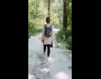 Woman walks over fluffy covered woods trail