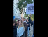 Man hold sign about Uber at Marathon