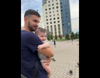 Father hold baby laugh at pigeons street