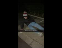 Guy jumps over shrub and lands on shoulder in parking lot