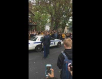 Teen girl in yellow shirt is being arrested by police, crowd chants 